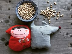 two stuffed animals sitting next to each other on top of a wooden table with corn