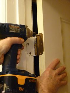 a man using a drill to fix a door