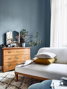 a living room with blue walls and white furniture