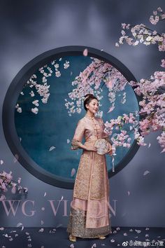 a woman standing in front of a painting with pink flowers on it and the words wg vision above her