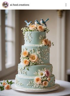 a blue wedding cake with flowers and birds on top