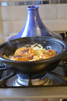 a skillet with some food cooking on top of it in front of a stove