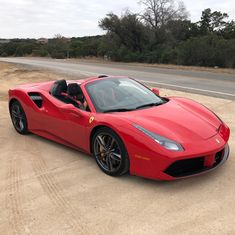 a red sports car is parked on the side of the road