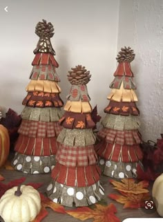 three decorative fall trees on a table with pumpkins