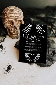 there is a card that says, my water broke on it next to some spider webs