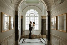 a man and woman standing next to each other in front of paintings on the wall