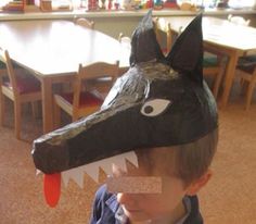 a young boy wearing a paper hat with an animal's head on it