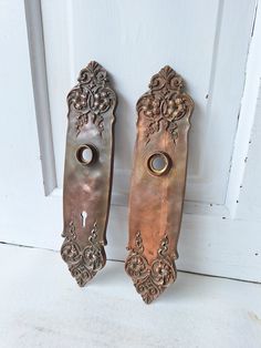 two ornate door handles on a white door