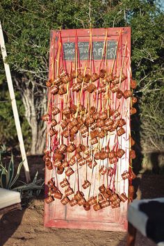 some food is hanging on sticks outside