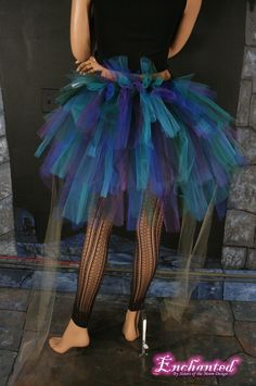 a woman is dressed in a blue and black tutu skirt with fishnet stockings