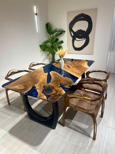 a wooden table sitting in front of a painting