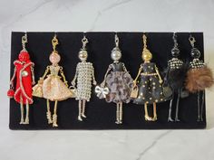 six pairs of earrings with different designs and colors on them, sitting in a display case