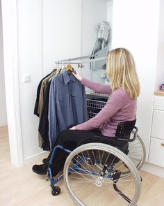 a woman in a wheel chair looking at clothes