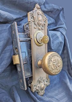 an old door handle with a lock on it and a blue cloth in the background