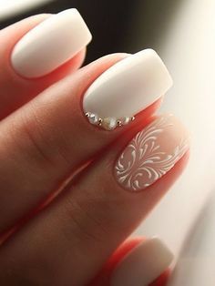 a woman's hand with white and silver manies on her nails, holding a ring