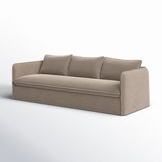 a beige couch sitting on top of a white floor