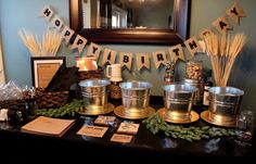 a table topped with metal buckets filled with drinks and decorations next to a mirror