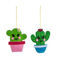 two felt cactus ornaments hanging from strings on a white background, one is green and the other is pink