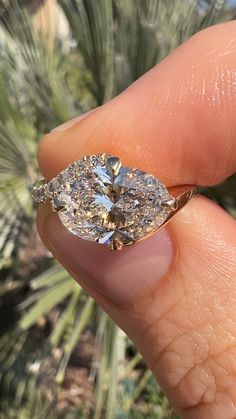 a person holding a diamond in their hand with the ring on it's finger