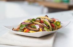 a white plate topped with salad on top of a table