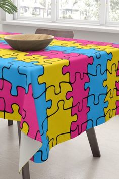 a table with a colorful puzzle design on it and a bowl sitting on top of the table