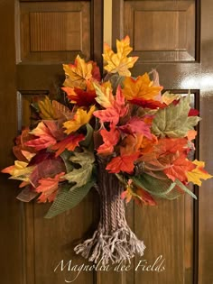 an autumn wreath is hanging on the front door