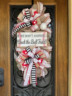 a baseball themed door hanger with the words we don't answer check the ball field