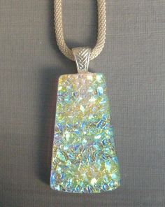 the pendant is made out of glass and has a silver chain around it's neck