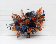 a bouquet of flowers sitting on top of a wooden table next to a white wall