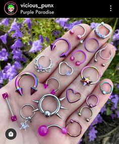 a person is holding many different types of rings and piercings in their hand,