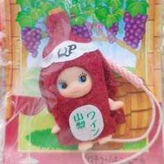 a doll with a red outfit and hat on it's head is in a plastic bag