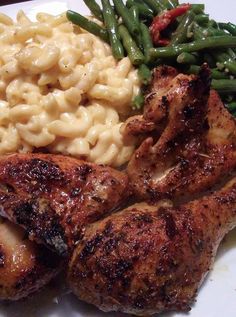 a plate with chicken, macaroni and green beans on it is seen in this image