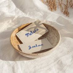 two paper tags are in a bowl on the snow