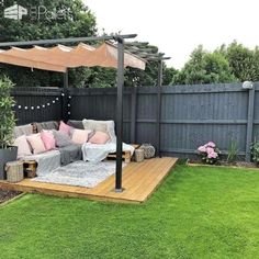 a couch sitting on top of a wooden deck in a backyard next to a fence