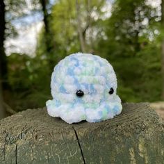 a small stuffed animal sitting on top of a tree stump