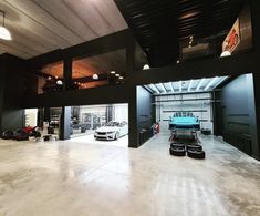 an empty garage with two cars parked in the space between it and another car on the other side