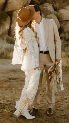 a bride and groom kissing in the desert