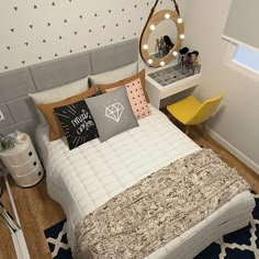 a bed room with a neatly made bed next to a dresser and mirror on the wall