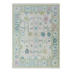 a white rug with blue, green and pink designs on the bottom half of it