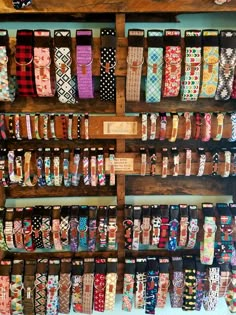 many different types of bracelets are on display in a wooden rack with labels and tags