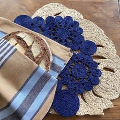 a hat is sitting on top of a placemat with blue crocheted doily