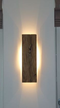 a wooden plaque mounted to the side of a white wall next to a light fixture