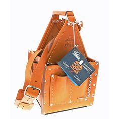 an orange leather bag with a book in it's pocket and a chain hanging from the front