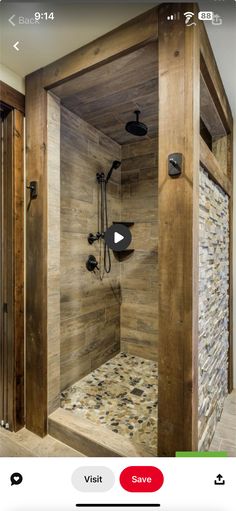 a walk in shower sitting inside of a bathroom next to a wooden wall and floor