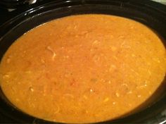 a crock pot filled with soup sitting on top of a stove