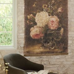 a painting hanging on the wall next to a chair in front of a brick wall