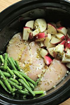 chicken, potatoes and green beans in a crock pot with seasoning on top