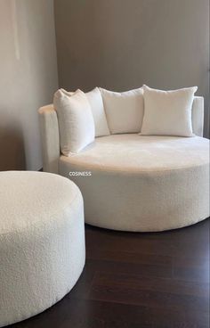 a white round couch and ottoman in a living room