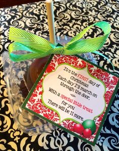 an apple in a plastic container with a green bow on it's head and label