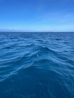 the water is very blue and there are clouds in the sky